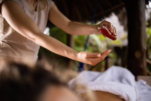 Thai Lamai - salon masażu tajskiego Poznań. Masażystka wlewająca olejek na dłoń przed masażem.
